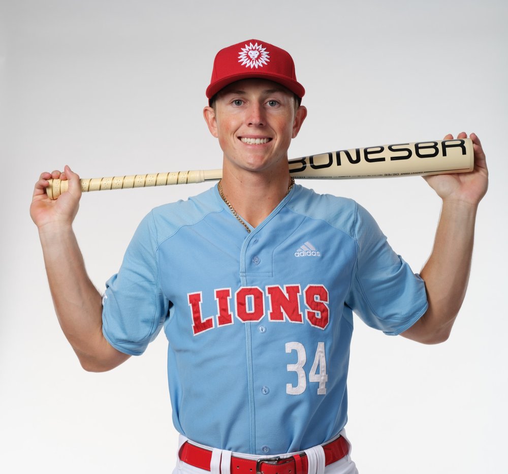Zach Wadas wearing LMU Lions number 34, bat on his shoulders — media day studio portrait